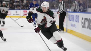Feb 29, 2024; Toronto, Ontario, CAN; Arizona Coyotes defenseman J.J. Moser (90) carries the puck against the Toronto Maple Leafs during the third period at Scotiabank Arena. Mandatory Credit: John E. Sokolowski-USA TODAY Sports