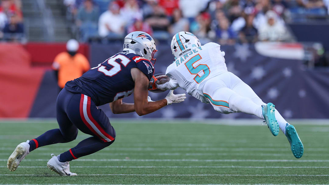 Oct 6, 2024; Foxborough, Massachusetts, USA; Miami Dolphins cornerback Jalen Ramsey (5) breaks up a pass to New England Patriots tight end Hunter Henry (85) during the second half at Gillette Stadium. Mandatory Credit: Paul Rutherford-Imagn Images
