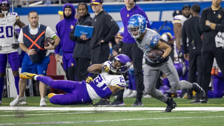 Jan 7, 2024; Detroit, Michigan, USA; Detroit Lions wide receiver Amon-Ra St. Brown (14) catches a pass and shakes a tackle attempt by Minnesota Vikings cornerback Akayleb Evans (21) during first quarter at Ford Field. Mandatory Credit: David Reginek-USA TODAY Sports