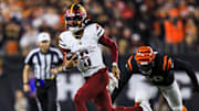 Washington Commanders quarterback Jayden Daniels runs with the ball against the Cincinnati Bengals in the second half at Paycor Stadium.