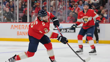 Dec 2, 2025; Sunrise, Florida, USA; Florida Panthers defenseman Aaron Ekblad (5) shoots the puck against the Toronto Maple Leafs during the third period at Amerant Bank Arena. Mandatory Credit: Sam Navarro-Imagn Images
