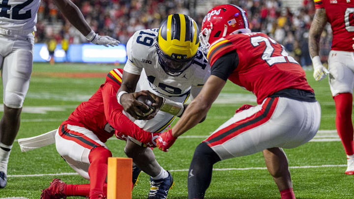 Nov 22, 2025; College Park, Maryland, USA;  Michigan Wolverines quarterback Bryce Underwood (19) dives towards the pilon as Maryland Terrapins defensive back Jalen Huskey (22) tackles during the second half at SECU Stadium. Mandatory Credit: Tommy Gilligan-Imagn Images