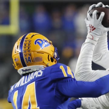 Oct 14, 2023; Pittsburgh, Pennsylvania, USA; Louisville Cardinals wide receiver Jimmy Calloway (7) makes a catch along the sidelines against Pittsburgh Panthers defensive back Marquis Williams (14) during the fourth quarter at Acrisure Stadium. 