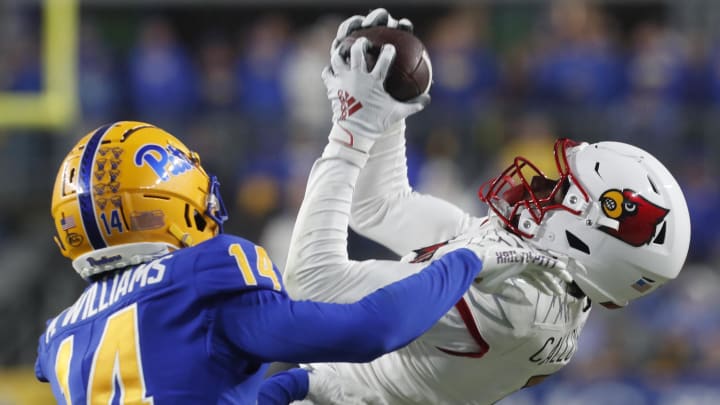 Oct 14, 2023; Pittsburgh, Pennsylvania, USA; Louisville Cardinals wide receiver Jimmy Calloway (7) makes a catch along the sidelines against Pittsburgh Panthers defensive back Marquis Williams (14) during the fourth quarter at Acrisure Stadium. 