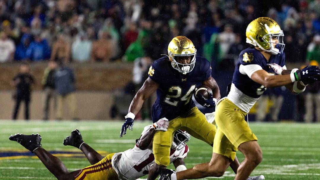 Oct 18, 2025; South Bend, Indiana, USA; Notre Dame Fighting Irish running back Jadarian Price (24) runs the ball while Southern California Trojans cornerback Decarlos Nicholson (17) defends in the second half at Notre Dame Stadium. Mandatory Credit: Trevor Ruszkowski-Imagn Images