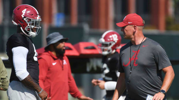 Alabama head coach Kalen DeBoer speaks with quarterback Jalen Milroe at fall camp.