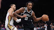 Dec 6, 2025; Brooklyn, New York, USA; Brooklyn Nets center Nic Claxton (33) dribbles as New Orleans Pelicans guard Jordan Hawkins (24) defends during the second half at Barclays Center. Mandatory Credit: Vincent Carchietta-Imagn Images
