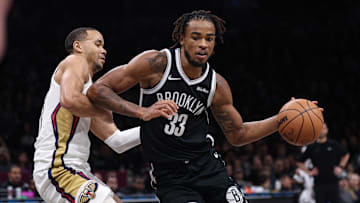 Dec 6, 2025; Brooklyn, New York, USA; Brooklyn Nets center Nic Claxton (33) dribbles as New Orleans Pelicans guard Jordan Hawkins (24) defends during the second half at Barclays Center. Mandatory Credit: Vincent Carchietta-Imagn Images