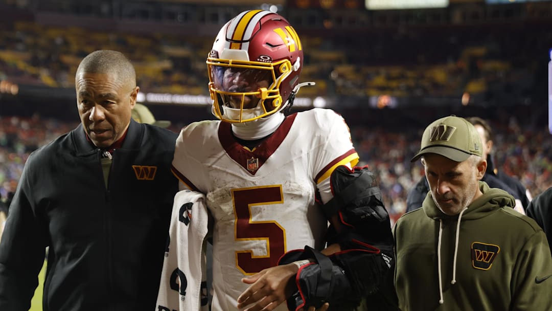 Nov 2, 2025; Landover, Maryland, USA; Washington Commanders quarterback Jayden Daniels (5) is helped off the field after an injury during the second half against the Seattle Seahawks at Northwest Stadium. Mandatory Credit: Amber Searls-Imagn Images