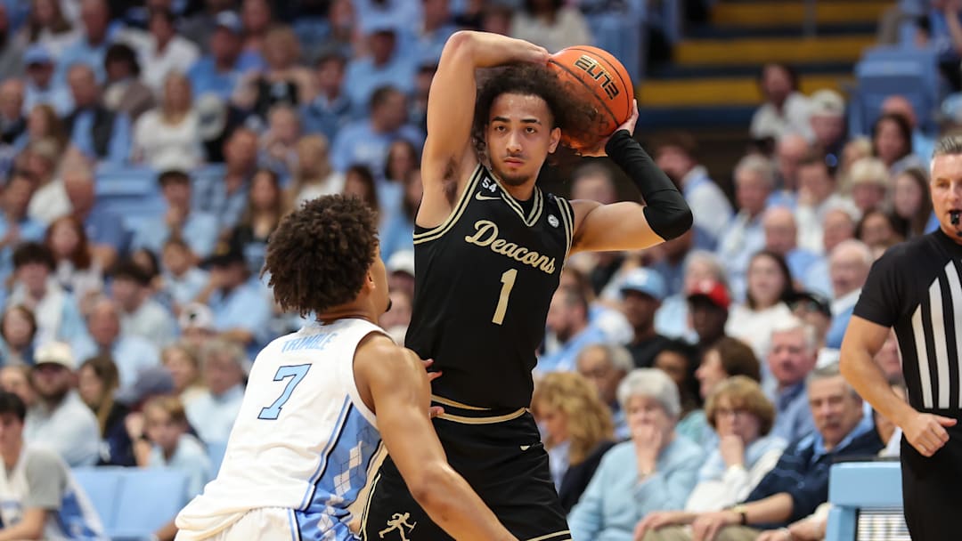 Jan 10, 2026; Chapel Hill, North Carolina, USA; Wake Forest Demon Deacons guard Nate Calmese (1) sets the play with North Carolina Tar Heels guard Seth Trimble (7) defending during the first half at Dean E. Smith Center. Mandatory Credit: Cory Knowlton-Imagn Images