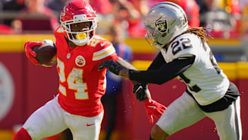 Oct 19, 2025; Kansas City, Missouri, USA; Kansas City Chiefs running back Brashard Smith (24) carries the ball defended by Las Vegas Raiders cornerback Eric Stokes (22) during the fourth quarter of the game at GEHA Field at Arrowhead Stadium.