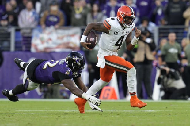 Quarterback runs away from diving defender.