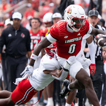 Louisville Cardinals wide receiver Chris Bell (0) runs down the field through Austin Peay Governors defensive back Cinque Williams (4) hold during their game on Saturday, Aug. 31, 2024 at L&N Federal Credit Union Stadium in Louisville, Ky.