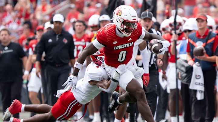 Louisville Cardinals wide receiver Chris Bell (0) runs down the field through Austin Peay Governors defensive back Cinque Williams (4) hold during their game on Saturday, Aug. 31, 2024 at L&N Federal Credit Union Stadium in Louisville, Ky.