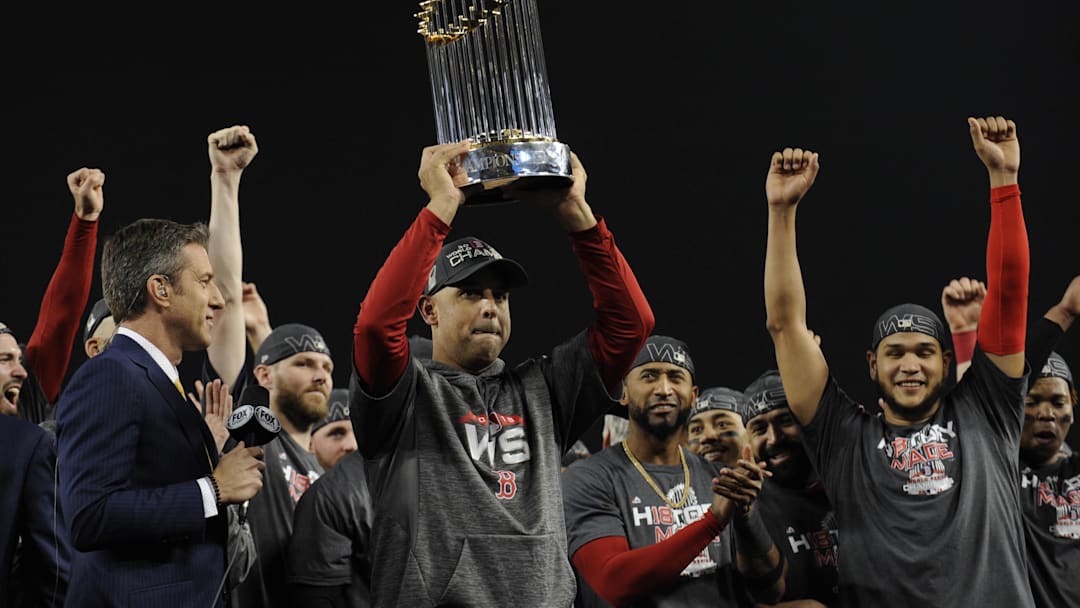 Boston Red Sox manager Alex Cora hoists the Commissioner's Trophy after defeating the Los Angeles Dodgers in game five of the 2018 World Series at Dodger Stadium.