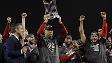 Boston Red Sox manager Alex Cora hoists the Commissioner's Trophy after defeating the Los Angeles Dodgers in game five of the 2018 World Series at Dodger Stadium.
