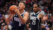 Mar 29, 2024; Sacramento, California, USA; Dallas Mavericks guard Dante Exum (0) holds onto a rebound in front of forward P.J. Washington (25) against the Sacramento Kings in the fourth quarter at the Golden 1 Center. Mandatory Credit: Cary Edmondson-Imagn Images