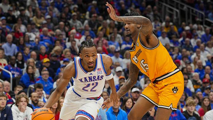 Dec 7, 2025; Kansas City, Missouri, USA; Kansas Jayhawks guard Darryn Peterson (22) drives against Missouri Tigers center Shawn Phillips Jr. (15) during the first half at T-Mobile Center. Mandatory Credit: Jay Biggerstaff-Imagn Images