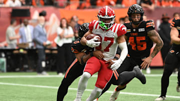 Jun 15, 2024; Vancouver, British Columbia, CAN; during the first half Calgary Stampeders wide receiver Erik Brooks (87) runs with the ball against BC Lions defensive lineman Sione Teuhema (0) at BC Place. Mandatory Credit: Simon Fearn-Imagn Images