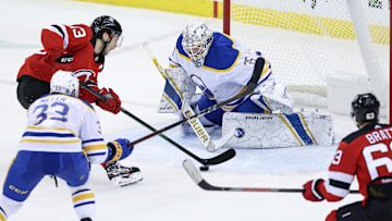Feb 23, 2021; Newark, New Jersey, USA; New Jersey Devils center Nico Hischier (13) skates with the puck toward Buffalo Sabres goaltender Linus Ullmark (35) during the second period at Prudential Center. Mandatory Credit: Vincent Carchietta-Imagn Images