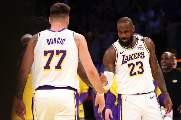 Los Angeles Lakers forward LeBron James (23) and guard Luka Dončić (77) react after a play during the first quarter against t