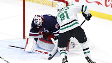 Nov 9, 2024; Winnipeg, Manitoba, CAN; Winnipeg Jets goaltender Connor Hellebuyck (37) makes a stick save on a Dallas Stars left wing Jason Robertson (21) shot in the third period at Canada Life Centre. Mandatory Credit: James Carey Lauder-Imagn Images