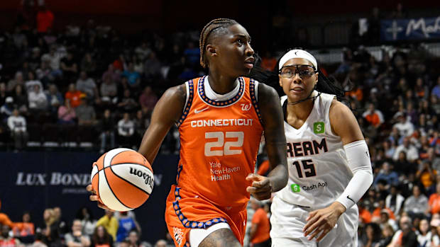 Connecticut Sun guard Saniya Rivers drives to the basket past a defender while wearing her orange uniform