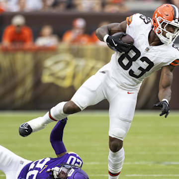 Aug 17, 2024; Cleveland, Ohio, USA; Cleveland Browns tight end Zaire Mitchell-Paden (83) runs the ball while slipping a tackle by Minnesota Vikings safety Jay Ward (20) during the third quarter at Cleveland Browns Stadium. Mandatory Credit: Scott Galvin-Imagn Images