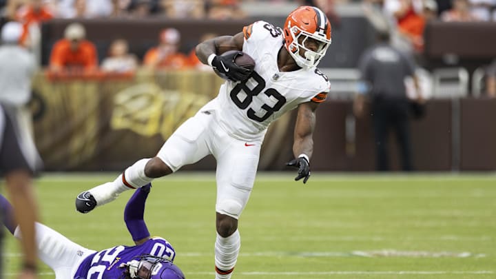 Aug 17, 2024; Cleveland, Ohio, USA; Cleveland Browns tight end Zaire Mitchell-Paden (83) runs the ball while slipping a tackle by Minnesota Vikings safety Jay Ward (20) during the third quarter at Cleveland Browns Stadium. Mandatory Credit: Scott Galvin-Imagn Images