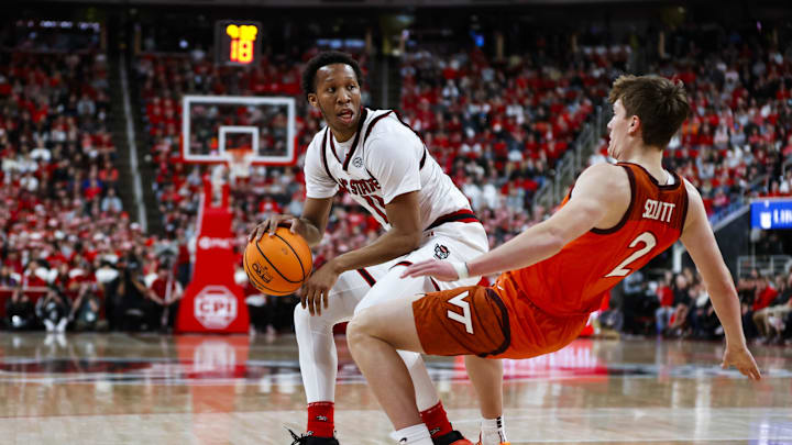 Feb 7, 2026; Raleigh, North Carolina, USA; NC State Wolfpack guard Quadir Copeland (11) with the ball shoves Virginia Tech Hokies guard Jaden Schutt (2) during the first half of the game at Lenovo Center. Mandatory Credit: Jaylynn Nash-Imagn Images