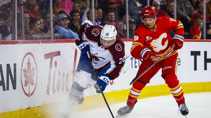 Apr 14, 2026; Calgary, Alberta, CAN; Colorado Avalanche center Ross Colton (20) and Calgary Flames defenseman Zayne Parekh (19) battle for the puck during the third period at Scotiabank Saddledome. Mandatory Credit: Sergei Belski-Imagn Images