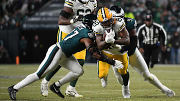 Jan 12, 2025; Philadelphia, Pennsylvania, USA; Green Bay Packers running back Josh Jacobs (8) rushes the ball against Philadelphia Eagles defensive tackle Milton Williams (93) and linebacker Nakobe Dean (17) during the first half in an NFC wild card game at Lincoln Financial Field. Mandatory Credit: Eric Hartline-Imagn Images