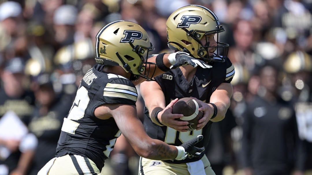 Purdue Boilermakers quarterback Ryan Browne (15) hands the ball off to Purdue Boilermakers running back Antonio Harris (22)