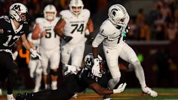Nov 1, 2025; Minneapolis, Minnesota, USA; Michigan State Spartans wide receiver Omari Kelly (1) runs the ball as Minnesota Golden Gophers defensive back Kerry Brown (14) defends during the second half at Huntington Bank Stadium. Mandatory Credit: Matt Krohn-Imagn Images