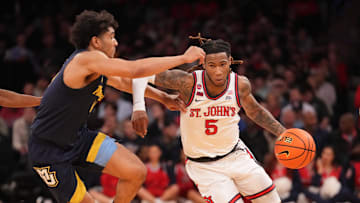 Mar 14, 2025; New York, NY, USA;  St. John's basketball guard Deivon Smith (5) drives on Marquette Golden Eagles guard Stevie Mitchell (4) in the first half at Madison Square Garden.