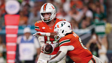 Sep 13, 2025; Miami Gardens, Florida, USA; Miami Hurricanes quarterback Carson Beck (11) hands off to running back CharMar Brown (6) against the South Florida Bulls in the second quarter at Hard Rock Stadium. Mandatory Credit: Nathan Ray Seebeck-Imagn Images