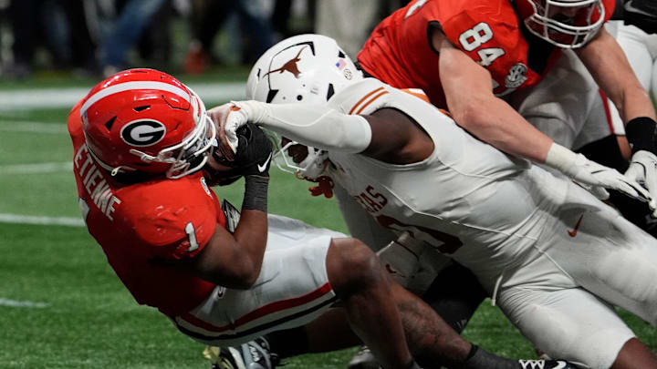 Georgia running back Trevor Etienne (1) powers past Texas linebacker Anthony Hill Jr. (0) to score the game winning touchdown during overtime of the SEC championship game against Texas in Atlanta, on Saturday, Dec. 7, 2024.