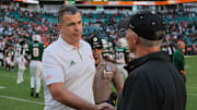 Nov 23, 2024; Miami Gardens, Florida, USA; Miami Hurricanes head coach Mario Cristobal shakes hands with Wake Forest Demon Deacons head coach Dave Clawson after the game at Hard Rock Stadium. Mandatory Credit: Sam Navarro-Imagn Images