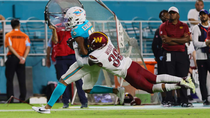 Miami Dolphins wide receiver Erik Ezukanma (18) catches the football against Washington Commanders cornerback A.J. Woods (38) during the third quarter of a preseason game at Hard Rock Stadium.