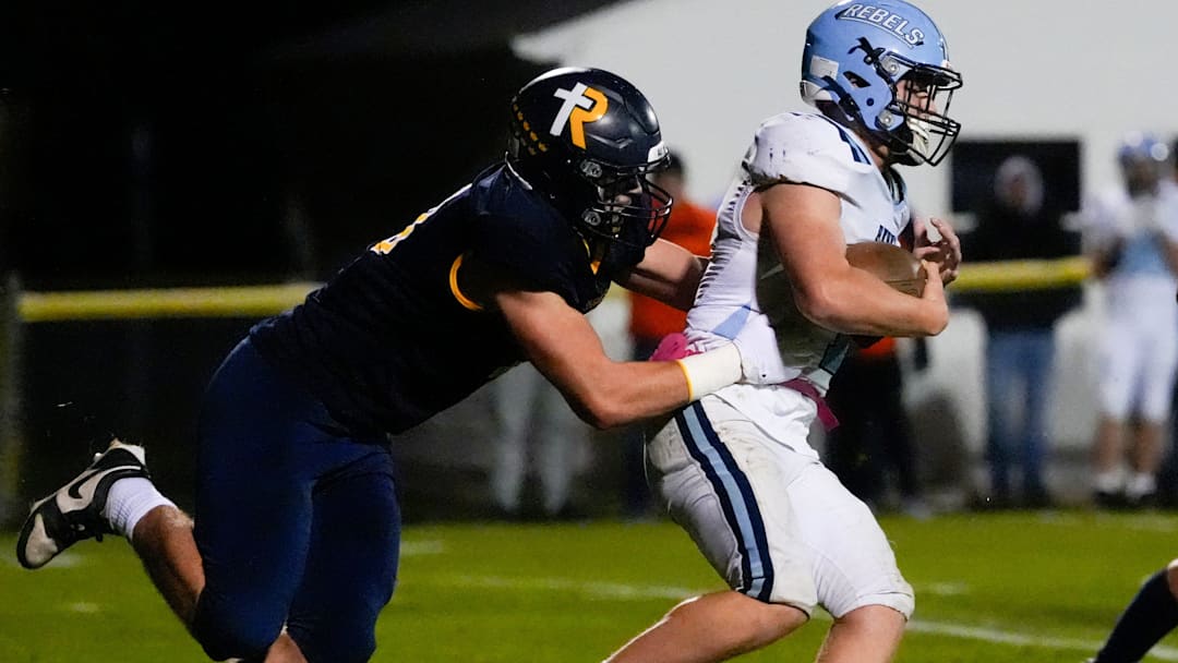 Regina’s Tate Wallace (0) looks to tackle Northeast’s Maxzen Eskildsen (1) during a Class 1A playoff game Oct. 24, 2025 in Iowa City, Iowa.