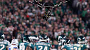 A suspended television camera hovers over players during a game between the Philadelphia Eagles and the Dallas Cowboys.