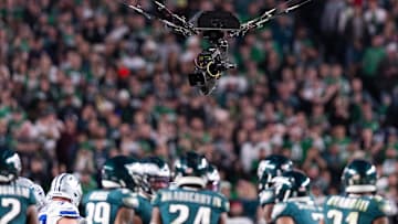 A suspended television camera hovers over players during a game between the Philadelphia Eagles and the Dallas Cowboys.
