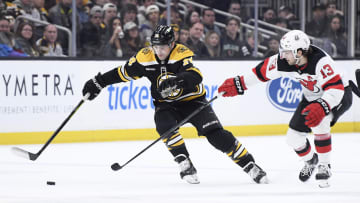 Apr 8, 2023; Boston, Massachusetts, USA;  New Jersey Devils center Nico Hischier (13) tries to poke the puck away from Boston Bruins left wing Jake DeBrusk (74) during the first period at TD Garden. Mandatory Credit: Bob DeChiara-USA TODAY Sports