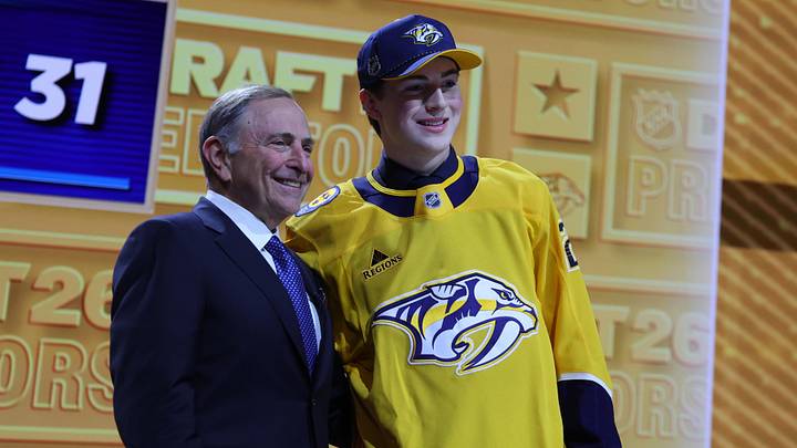 Jun 26, 2026; Buffalo, New York, USA; Tommy Bleyl reacts beside NHL commissioner Gary Bettman after being selected with the thirty first pick in the first round of the 2026 NHL Draft by the Nashville Predators at KeyBank Center. Mandatory Credit: Timothy T. Ludwig-Imagn Images