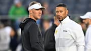 Oct 14, 2023; South Bend, Indiana, USA; USC Trojans head coach Lincoln Riley and Notre Dame Fighting Irish head coach Marcus Freeman chat before the game at Notre Dame Stadium.