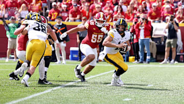 Sep 6, 2025; Ames, Iowa, USA; Iowa Hawkeyes quarterback Mark Gronowski (11) scrambles under pressure from Iowa State Cyclones defensive lineman Jace J. Gilbert (55) during the second half at Jack Trice Stadium. Mandatory Credit: Reese Strickland-Imagn Images