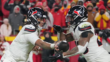 Jan 18, 2025; Kansas City, Missouri, USA; Houston Texans quarterback C.J. Stroud (7) hands off to running back Joe Mixon (28) against the Kansas City Chiefs during the second half of a 2025 AFC divisional round game at GEHA Field at Arrowhead Stadium. Mandatory Credit: Denny Medley-Imagn Images