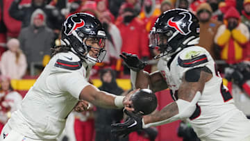Jan 18, 2025; Kansas City, Missouri, USA; Houston Texans quarterback C.J. Stroud (7) hands off to running back Joe Mixon (28) against the Kansas City Chiefs during the second half of a 2025 AFC divisional round game at GEHA Field at Arrowhead Stadium. Mandatory Credit: Denny Medley-Imagn Images
