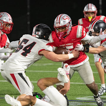 Wellesley junior captain Brandon Hollingsworth (54, left) and junior captain Matthew Leibman (right) combine their efforts to bring down Catholic Memorial junior Isaiah Simmons during the Division 2 state semifinals game at Weston High, Nov. 22, 2024. The Knights defeated the Raiders, 49-7.