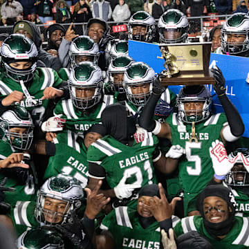 Members of the Winslow Township High School football team celebrate with their trophy after Winslow defeated Phillipsburg, 35-0, in the State Group 4 football final played at SHI Stadium at Rutgers University in Piscataway on Wednesday, December 4, 2024.